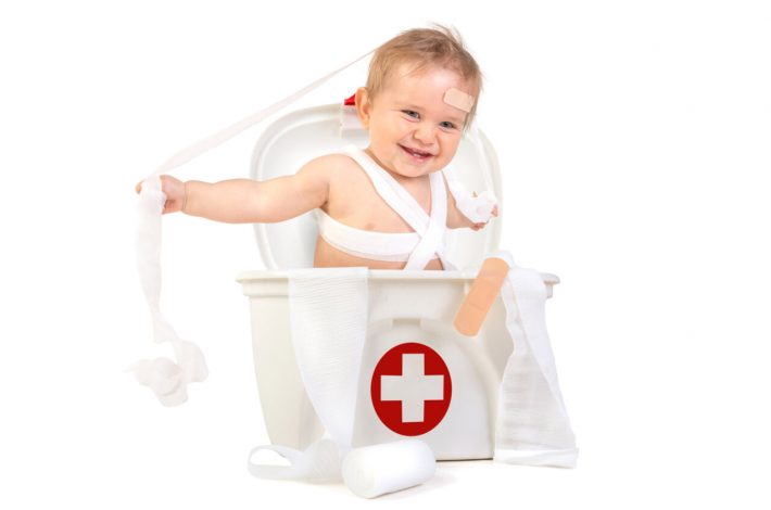 A cute little boy inside the baby first aid kit.