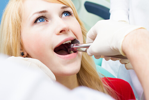 woman in dentist for emergency tooth extraction