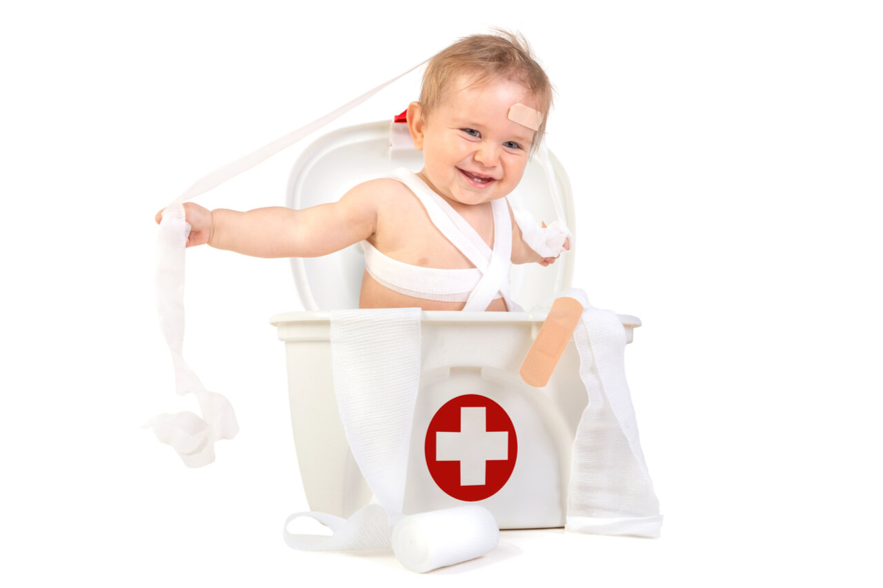 A cute little boy inside the baby first aid kit.
